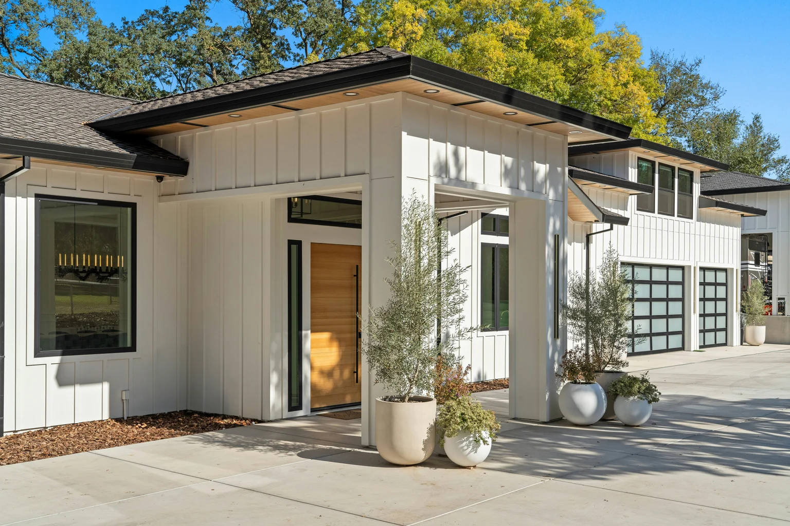 Finished white contemporary home with a layered charcoal shingle roof